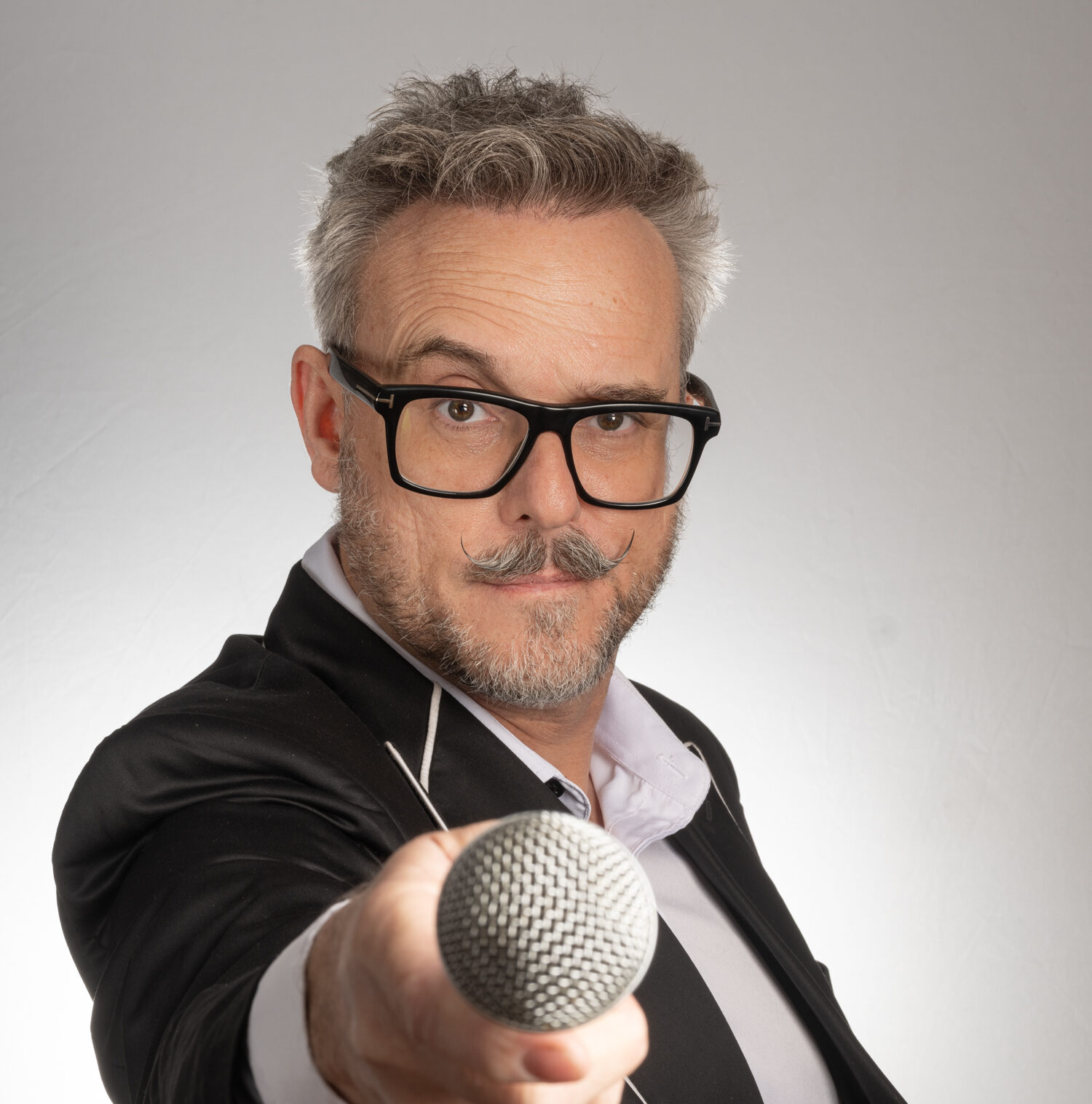 Portrait of the magician Loki holding a Microphone to the camera